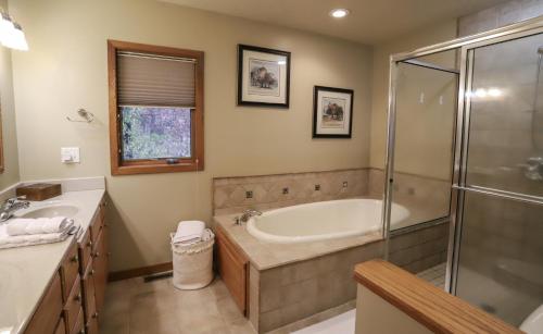 a bathroom with a tub and a glass shower at LakePlace Bed & Breakfast in Dresser