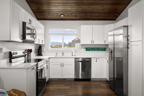 a kitchen with white cabinets and a wooden ceiling at The Kabins in Columbia Falls