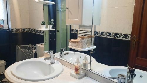 een badkamer met een wastafel en een spiegel bij Ana Paula House in Aveiro