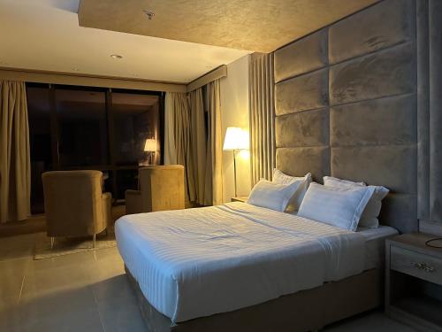 a hotel room with a large bed with white pillows at اطلالة الحوراء in Umm Lujj