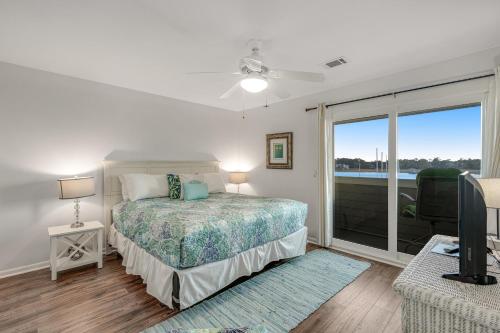 een slaapkamer met een bed en een groot raam bij Mariners Cay 68 in Folly Beach
