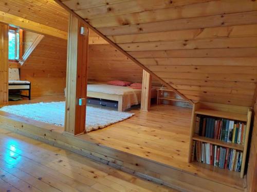 a bedroom in a log cabin with a bed at "Kod dva kestena"Warm and cozy house with lake view sauna in Međuvršje