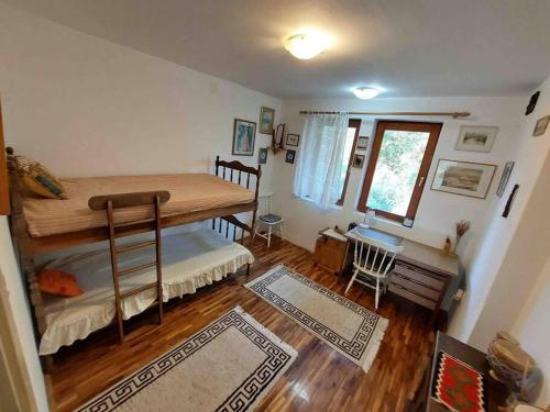 a room with a bunk bed and a desk in it at "Kod dva kestena"Warm and cozy house with lake view sauna in Međuvršje