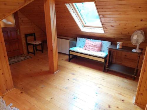 a attic room with a bench and a window at "Kod dva kestena"Warm and cozy house with lake view sauna in Međuvršje