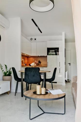 a living room with a table and chairs and a kitchen at Apartamenty Belni Hel Edyta i Maciej Wolak in Hel