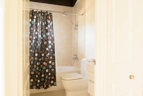 y baño con aseo y cortina de ducha. en Cabaña Papaya: 3br 2bth Retreat!!, en Falmouth