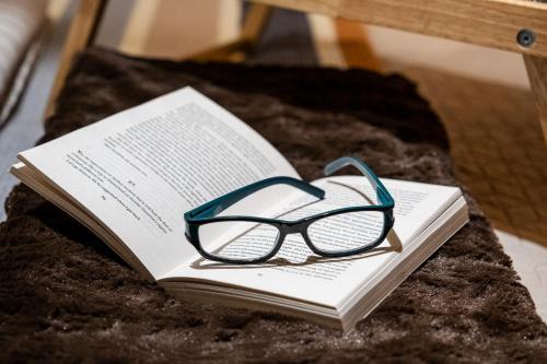 a pair of glasses sitting on top of a book at Bohemian Elly room Varna in Varna City
