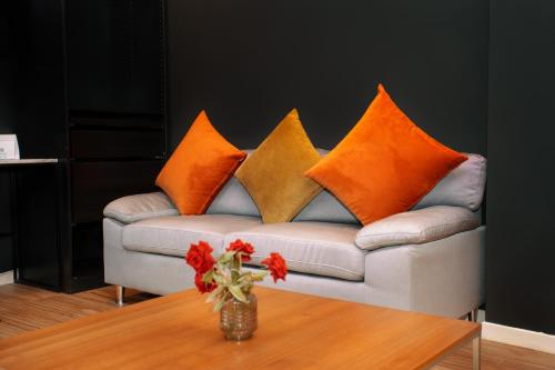 a couch with four pillows on it with a table at Hill Valley Asilah - Luxury Living & Boutique Hotel in Asilah