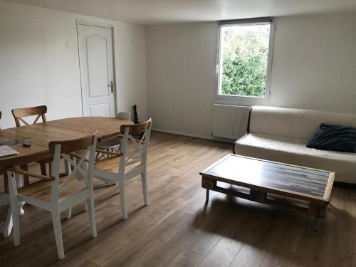 a living room with a table and a couch at Le Fort Vauban in Ambleteuse
