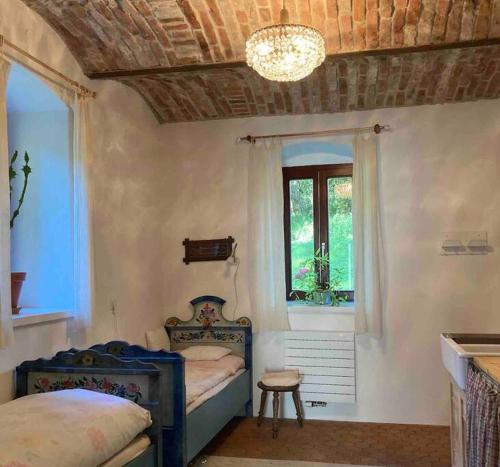 - une chambre avec deux lits, une fenêtre et un lustre dans l'établissement Familien-Apartment in kleiner Waldvilla Semmering, 