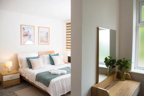 a bedroom with a large bed with a mirror at Manchester Apartments by BEVOLVE - Free Parking in Manchester