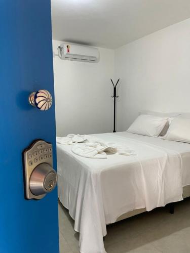 a bedroom with a white bed with a fan at Suite Grega 5- Centro da Vila Abrãao in Abraão