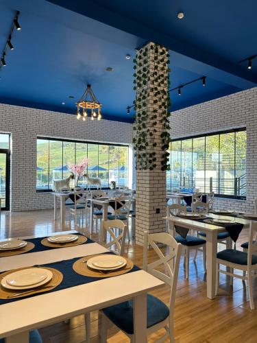 a dining room with tables and chairs and blue ceilings at Qızıl Farel (Ailəvi İstirahət Mərkəzi) in İsmayıllı