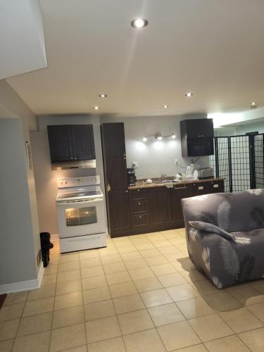 een woonkamer met een bank en een keuken met een oven bij Lovely Guest Entire Apartment in Ottawa