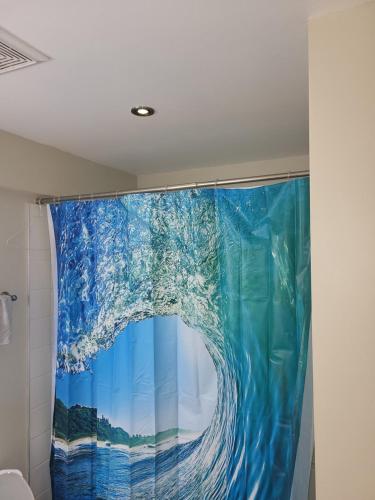 a shower curtain with a painting of a wave at Lovely Guest Entire Apartment in Ottawa
