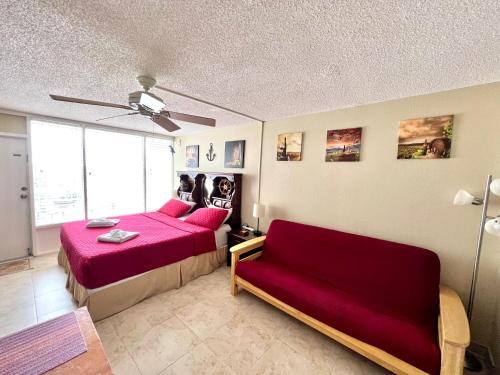 - une chambre avec un lit rouge et un canapé dans l'établissement Wine-y Beach 7th Floor Ocean View King Bed, à Daytona Beach Shores