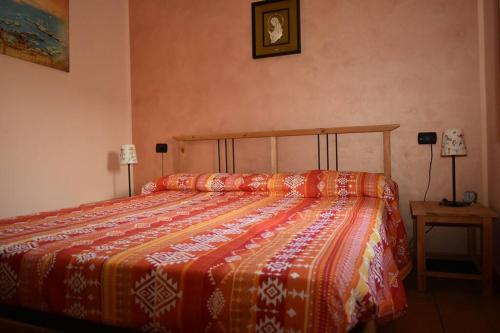 a bedroom with a bed with a colorful comforter at Casa vacanze Locus Amoenus in Sant'Agata de' Goti