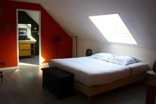 a bedroom with a large bed with a skylight at Ti Guernevez - La Longère in Briec