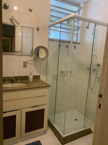 a bathroom with a glass shower and a sink at Praia mais charmosa do Rio in Rio de Janeiro
