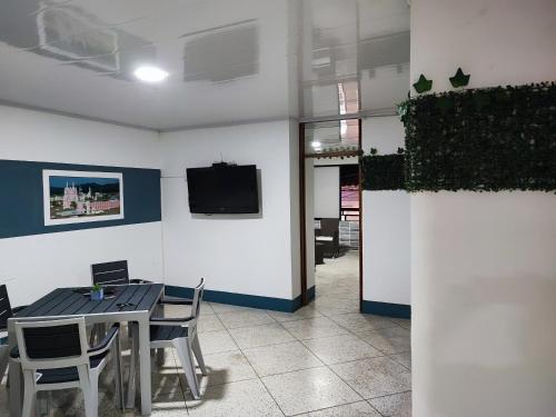 - une salle à manger avec une table, des chaises et une télévision dans l'établissement BUGA Casa Palermo Boutique Hotel, à Buga