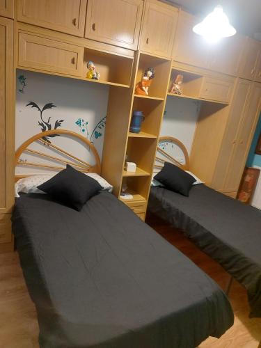 a bedroom with two beds and a book shelf at Ría de vigo in Vigo