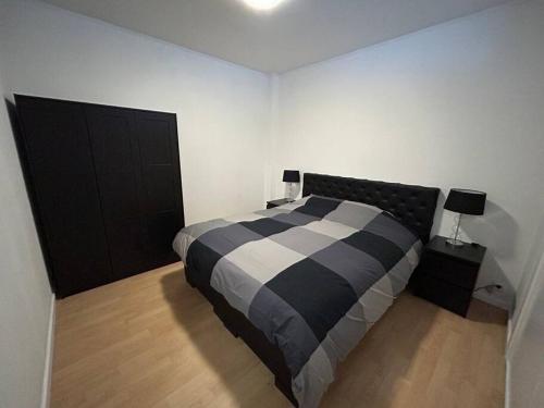 - une chambre avec un lit noir et blanc et 2 lampes dans l'établissement Appartement Brussels Expo Atomium, à Grimbergen