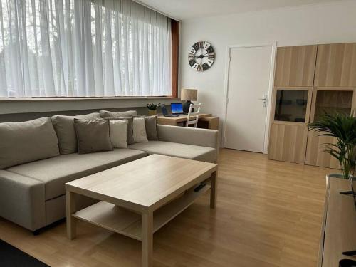 een woonkamer met een bank en een salontafel bij Appartement Brussels Expo Atomium in Grimbergen
