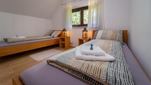1 dormitorio con 2 camas y toallas. en Kuća za odmor Zeleni san en Lič