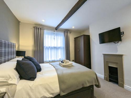 een slaapkamer met een bed, een tv en een open haard bij The Barbican in York