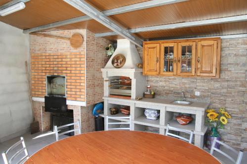 a kitchen with a table and a stove top oven at Casa da Pizzaria in Carapito
