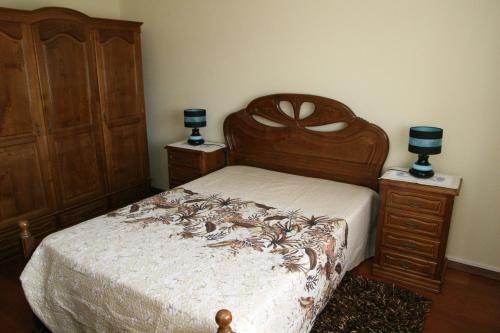 CarapitoにあるCasa da Pizzariaのベッドルーム1室(木製ベッド1台、ナイトスタンド2台付)