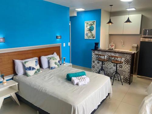 um quarto azul com uma cama grande e toalhas em SUITES VISTA MAR AZUL em Saquarema