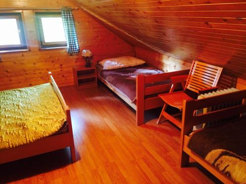 a room with a bed and chairs in a cabin at Turistična Kmetija Toman in Gornji Grad