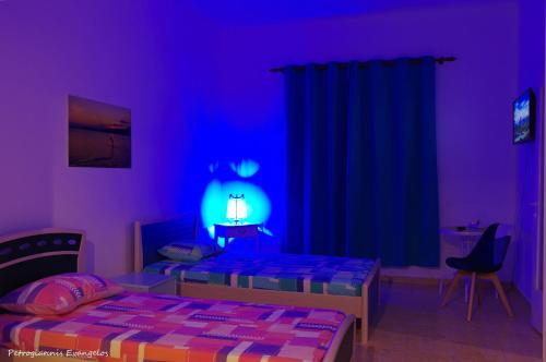 a bedroom with two beds and a purple room at Garden house in Amarinthos