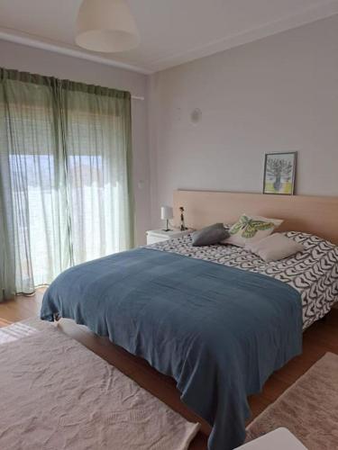 um quarto com uma cama grande e um cobertor azul em Merci Beach House em Carvoeira