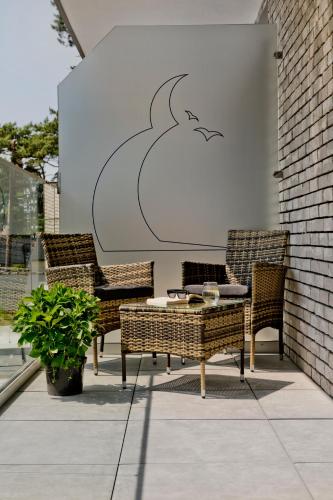 a table and chairs on a patio with a drawing of a bird at Apartamenty Belni Hel Edyta i Maciej Wolak in Hel