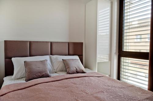 a bedroom with a large bed with two pillows at Apartamenty Belni Hel Edyta i Maciej Wolak in Hel