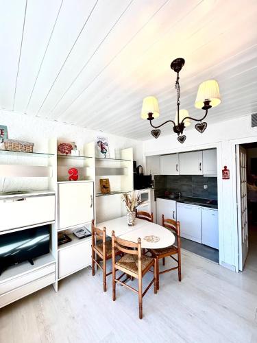 une cuisine avec des armoires blanches et une table et des chaises dans l'établissement Ski à 20m Telesiege 