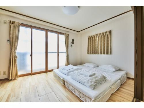 a bedroom with a large bed and a large window at Kyoto Hostel family room / Vacation STAY 8181 in Nishinotōindōri