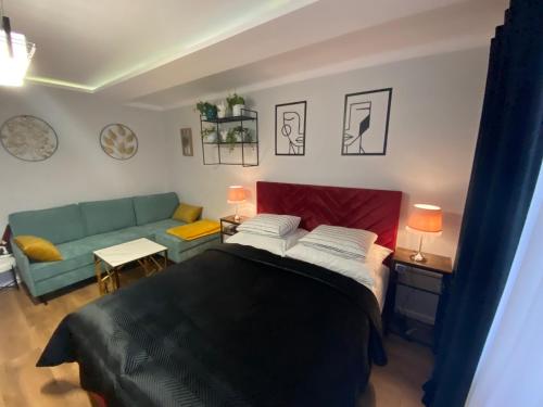 une chambre avec un lit et un canapé dans l'établissement Apartament ,, Sen i Kawa'' - komfortowy nocleg w sercu aglomeracji, à Bytom