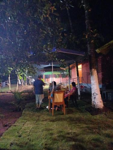 a group of people sitting at a table in a yard at amee's retreat in Diveagar