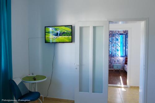 a room with a television hanging on the wall at Garden house in Amarynthos