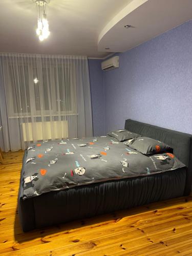 a bedroom with a bed with a black bedspread with cats on it at Апартаменты с двумя спальнями в центре города! in Cherkasy