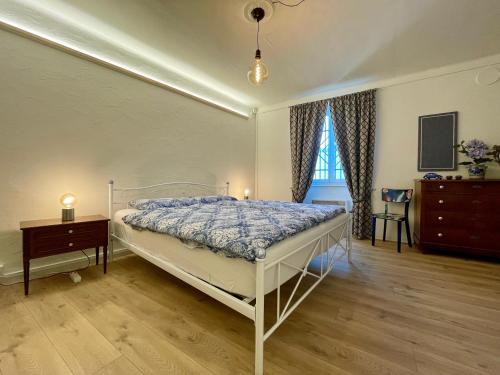 een slaapkamer met een bed, een dressoir en een raam bij 1912 - Blue Room - old town in Locarno