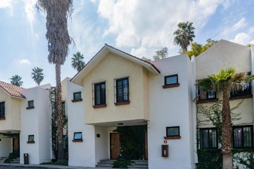 a house with palm trees in front of it at Hotel Flamingo Inn in Querétaro
