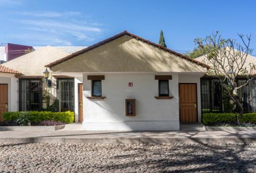 a small white house with a driveway at Hotel Flamingo Inn in Querétaro