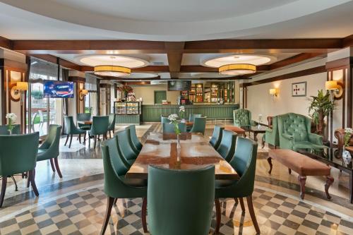 a dining room with a table and green chairs at Dobedan Exclusive Hotel & Spa ''Ex Brand Alva Donna Exclusive Hotel & Spa'' in Belek