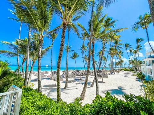 una playa con palmeras y el océano en CARIBBEAN Paradise WIFi HOTEL BAVARO Beach CLUB & SPA, en Punta Cana