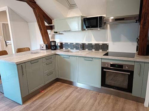 une cuisine avec des armoires bleues et un comptoir dans l'établissement Les Roseaux Comme à la maison prés des châteaux de la Loire, à Feings