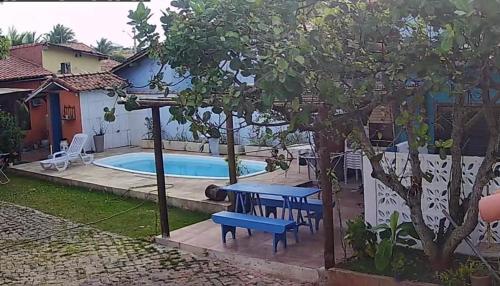 una mesa de picnic y un banco junto a una piscina en CASA DA BARRA- Suítes privativas em Saquarema, en Saquarema